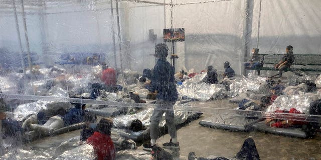 This March 20, 2021, a photo provided by the office of Representative Henry Cuellar, D-Texas, shows detainees at a Customs and Border Protection (CBP) temporary overflow facility in Donna, Texas. 