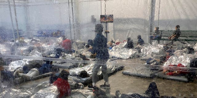 This March 20, 2021, a photo provided by the office of Representative Henry Cuellar, D-Texas, shows detainees at a Customs and Border Protection (CBP) temporary overflow facility in Donna, Texas. 