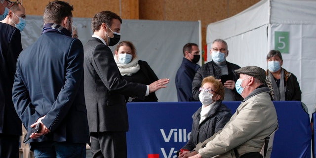 French President Emmanuel Macron talks to elderly people after they received a Pfizer COVID-19 vaccine at the vaccination center of Valenciennes, northern France, Tuesday, March 23, 2021. The French government has backed off from ordering a tough lockdown for Paris and several other regions despite an increasingly alarming situation at hospitals with a rise in the number of COVID-19 patients. (Yoan Valat/Pool Photo via AP)