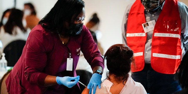 Health worker administers a dose of a Pfizer COVID-19 vaccine during a vaccination clinic at the Grand Yesha Ballroom in Philadelphia.  (AP Photo/Matt Rourke, File)