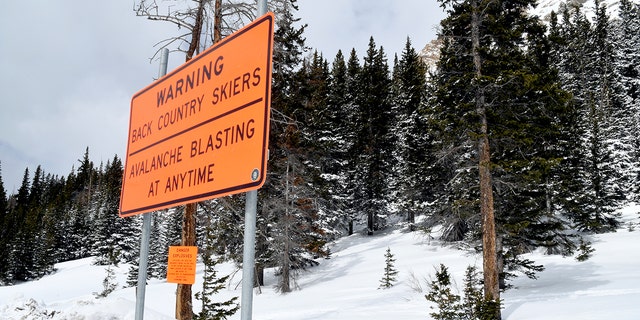 A sign warns backcountry users about avalanche blasting near the Continental Divide near Vail, Colo., Monday, March 22, 2021. Evan Hannibal, of Vail, and Tyler DeWitt, of Silverthorne, were involved in an avalanche in the area last spring that buried a service road and destroyed an expensive avalanche mitigation system. The two are scheduled to go to trial Thursday, March 25, 2021, on charges of misdemeanor reckless endangerment. Prosecutors also are seeking $168,000 in damages in the rare case that some worry could deter other backcountry skiers and snowboarders from coming forward to report avalanches out of fear of costly retribution. (AP Photo/Thomas Peipert)