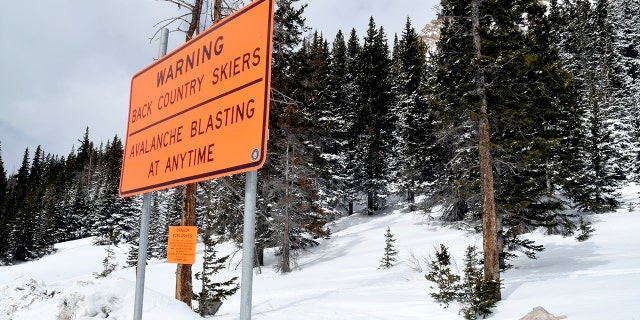 A sign warns backcountry users about avalanche blasting near the Continental Divide near Vail, Colo., Monday, March 22, 2021. Evan Hannibal, of Vail, and Tyler DeWitt, of Silverthorne, were involved in an avalanche in the area last spring that buried a service road and destroyed an expensive avalanche mitigation system. The two are scheduled to go to trial Thursday, March 25, 2021, on charges of misdemeanor reckless endangerment. Prosecutors also are seeking $168,000 in damages in the rare case that some worry could deter other backcountry skiers and snowboarders from coming forward to report avalanches out of fear of costly retribution. (AP Photo/Thomas Peipert)
