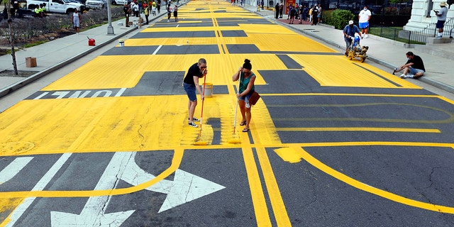 Volunteers Christine Ruth and Jenna Alcantara apply paint to a Black Lives Matter mural on Martin Luther King Jr. Boulevard in Atlantic City, N.J., Sept. 4, 2020. (Associated Press)