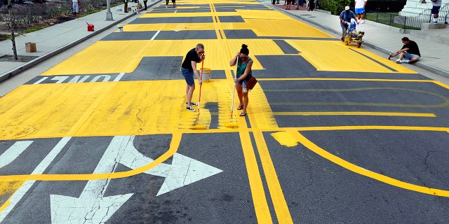 Volunteers Christine Ruth and Jenna Alcantara apply paint to a Black Lives Matter mural on Martin Luther King Jr. Boulevard in Atlantic City, N.J., Sept. 4, 2020. (Associated Press)