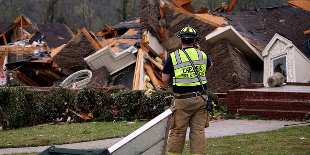 A firefighter surveys damage to a house where the family was trapped, but were able to get out after a tornado touched down south of Birmingham, Ala., March 25, 2021. (Associated Press)