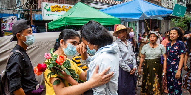 An anti-coup student protester is welcomed home with flowers by the residents of her neighborhood after being released from jail, Friday, March 26, 2021, in Yangon, Burma. (AP Photo)