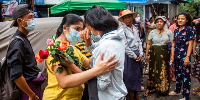 An anti-coup student protester is welcomed home with flowers by the residents of her neighborhood after being released from jail, Friday, March 26, 2021, in Yangon, Burma. (AP Photo)