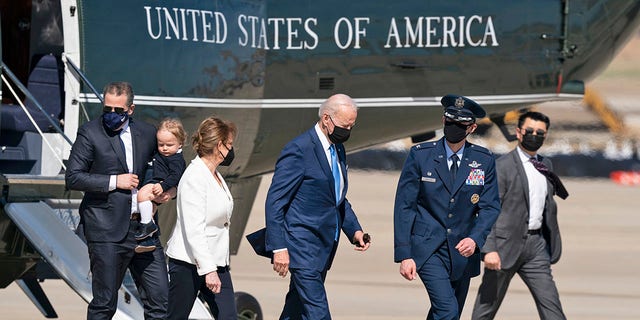President Joe Biden, center, switches from Marine One aboard Air Force One, with his son Hunter Biden, left, as he carries his son Beau, Friday, March 26, 2021, at Andrews Air Force Base.  (AP Photo / Alex Brandon)