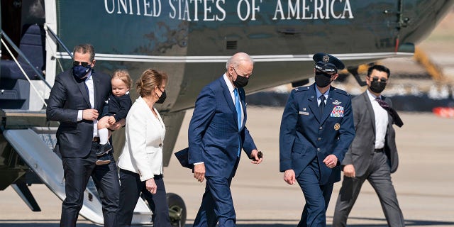 President Joe Biden, in the center, walks from Marine One aboard Air Force One, with son Hunter Biden, on the left, while carrying his son Beau, Friday, March 26, 2021, at Andrews Air Force Base, Md. Biden is on his way to Delaware. (AP Photo / Alex Brandon)