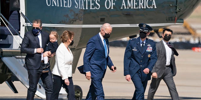 President Joe Biden, center, switches from Marine One aboard Air Force One, with his son Hunter Biden, left, as he carries his son Beau, Friday, March 26, 2021, at Andrews Air Force Base.  (AP Photo / Alex Brandon)