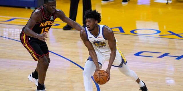 Golden State Warriors center James Wiseman (33) moves the ball past Atlanta Hawks center Clint Capela (15) during the first half of an NBA basketball game in San Francisco, Friday, March 26, 2021. (AP Photo/Tony Avelar)