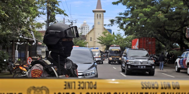 A police officer stands guard near a church where an explosion went off in Makassar, South Sulawesi, Indonesia, Sunday, March 28, 2021. (AP Photo/Yusuf Wahil)
