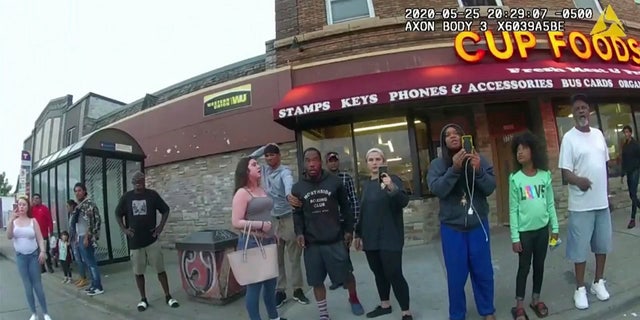 This image from a police body camera shows people gathering as former Minneapolis police officer Derek Chauvin was recorded pressing his knee on George Floyd's neck for several minutes as onlookers yelled at Chauvin to get off and Floyd saying that he couldn't breathe on May 25, 2020 in Minneapolis. 