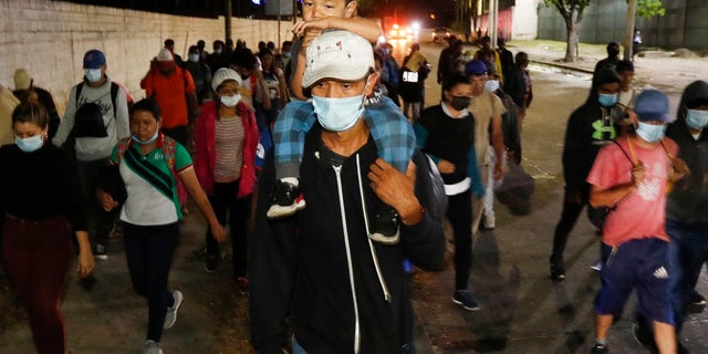 Les migrants qui souhaitent atteindre les États-Unis marchent le long d'une autoroute alors qu'ils quittent San Pedro Sula, au Honduras, avant l'aube de mardi.  (Photo AP / Delmer Martinez)