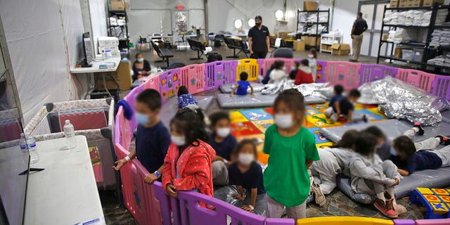 Young unaccompanied migrants, from ages 3 to 9, watch television inside a playpen at the U.S. Customs and Border Protection facility. (AP Photo/Dario Lopez-Mills, Pool)