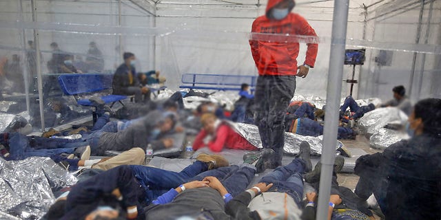 Young children lie inside a pod at the Donna Department of Homeland Security holding facility, the main detention center for unaccompanied children in the Rio Grande Valley run by U.S. Customs and Border Protection, in Donna, Texas, Tuesday, March 30, 2021.(AP Photo/Dario Lopez-Mills, Pool)