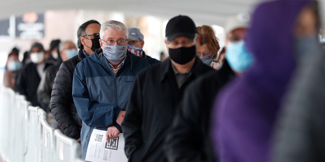 People wait in line at the check-in area to enter the United Center mass COVID-19 vaccination site Wednesday, March 10, 2021, in Chicago. 