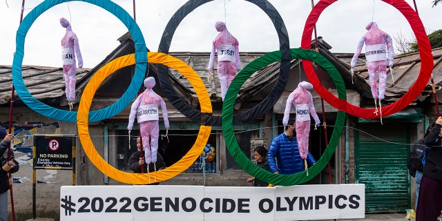 In this Feb. 3, 2021, file photo, exiled Tibetans use the Olympic rings as a prop as they hold a street protest against the holding of 2022 Winter Olympics in Beijing in Dharmsala, India. Some kind of boycott is almost sure to affect next year’s Beijing Winter Olympics. (AP Photo/Ashwini Bhatia, File)