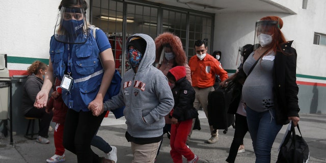 FILE - In this Friday, Feb. 26, 2021, file photo, a migrant family crosses the border into El Paso, Texas, in Ciudad Juarez, Mexico. (AP Photo/Christian Chavez, File)