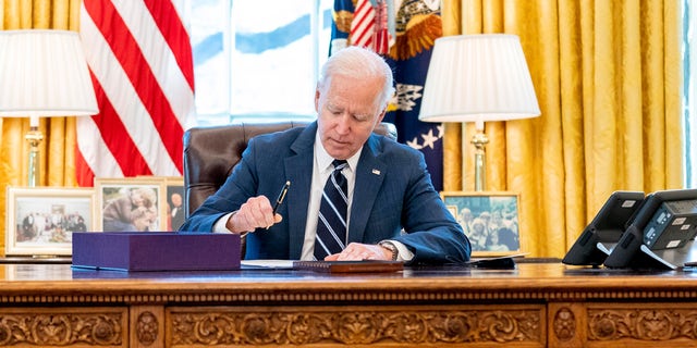 President Joe Biden signs the American Rescue Plan, a coronavirus relief package, in the Oval Office of the White House, Thursday, March 11, 2021, in Washington. (AP Photo/Andrew Harnik)