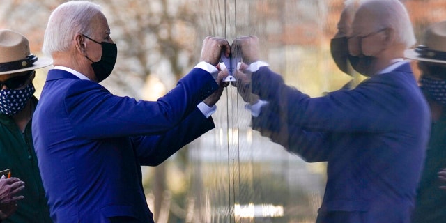 President Joe Biden makes a tracing of Cpl. Dennis F. Shine's name after laying flowers at the Vietnam Veterans Memorial in honor of Vietnam War Veterans Day on Monday, March 29, 2021, in Washington. (AP Photo/Evan Vucci)