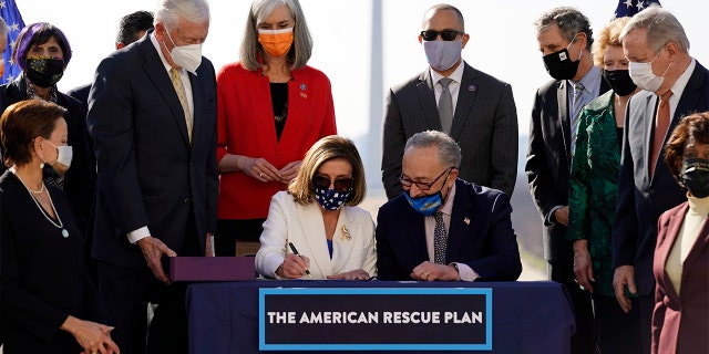 House Speaker Nancy Pelosi of Calif., signs the $1.9 trillion COVID-19 relief bill, accompanied by Senate Majority Leader Chuck Schumer of N.Y., during an enrollment ceremony on Capitol Hill, Wednesday, March 10, 2021, in Washington. (AP Photo/Alex Brandon)