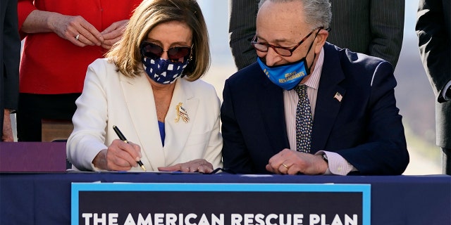 House Speaker Nancy Pelosi of Calif., signs the $1.9 trillion COVID-19 relief bill, accompanied by Senate Majority Leader Chuck Schumer of N.Y., during an enrollment ceremony on Capitol Hill, Wednesday, March 10, 2021, in Washington. (AP Photo/Alex Brandon)