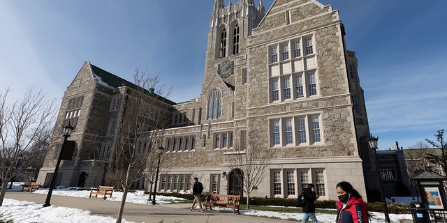 FILE - In this Feb. 17, 2021 file photo, students walk on the Boston College campus in Boston. (AP Photo/Michael Dwyer, File)