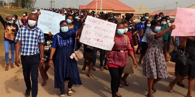 Nurses and supporters in Owo, Nigeria, participate in a march on Feb. 7, 2021, demanding the Federal Medical Centre in Owo provide security for its staff after two nurses were were attacked by the family of a deceased COVID-19 patient. (Tochukwu Q.O. via AP)