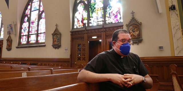 The Rev. Manuel Rodriguez sits in the pews of his church, Our Lady of Sorrows, on Friday, March 5, 2021, in the Queens borough of New York. (AP Photo/Jessie Wardarski)