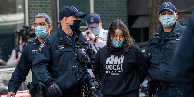 New York Police Officers arrest activists with VOCAL-NY after they blocked traffic on 3rd Ave. outside New York Gov. Andrew Cuomo's office, Wednesday, March 10, 2021, in New York. (AP Photo/Mary Altaffer)