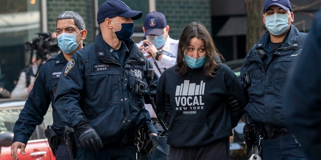 New York Police Officers arrest activists with VOCAL-NY after they blocked traffic on 3rd Ave. outside New York Gov. Andrew Cuomo's office, Wednesday, March 10, 2021, in New York. (AP Photo/Mary Altaffer)