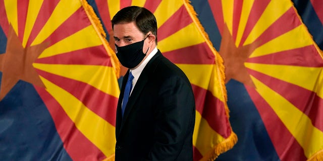 FILE - In this Dec. 2, 2020, file photo, Arizona Republican Gov. Doug Ducey arrives for a news conference to talk about the latest Arizona COVID-19 information in Phoenix. Ducey is prohibiting government mask mandates and allowing bars and nightclubs shuttered for months to open their doors without restrictions. Ducey's move Thursday, March 25, 2021, leaves in place few of the restrictions he implemented to curb the spread of the coronavirus. (AP Photo/Ross D. Franklin, Pool, File)