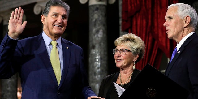 US Senator from West Virginia (D) Joe Manchin III is flanked his wife Gayle as he is sworn in by Vice President Mike Pence during the swearing-in re-enactments for recently elected senators in the Old Senate Chamber on Capitol Hill in Washington, DC January 3, 2019. (Photo by Alex EDELMAN / AFP) (Photo credit should read ALEX EDELMAN/AFP via Getty Images)