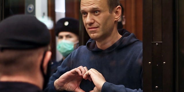Russian opposition leader Alexei Navalny makes a heart gesture during a hearing into an application by the Russian Federal Penitentiary Service to convert his suspended sentence of three and a half years in the Yves Rocher case into a real jail term on Feb. 2. (Moscow City Court Press OfficeTASS via Getty Images)