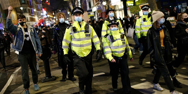 Des policiers surveillent les militants protestant contre la violence à l'égard des femmes et les nouveaux pouvoirs de police proposés manifestent à Londres, au Royaume-Uni, le 15 mars 2021 (Photo de David Cliff / Anadolu Agency via Getty Images)