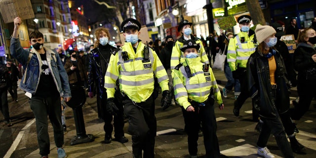 Des policiers surveillent les militants protestant contre la violence à l'égard des femmes et les nouveaux pouvoirs de police proposés manifestent à Londres, au Royaume-Uni, le 15 mars 2021 (Photo de David Cliff / Anadolu Agency via Getty Images)