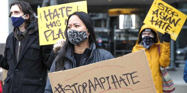 Trish Villanueva (C) of Seattle holds a sign with the hashtag "stop AAPI hate" during the We Are Not Silent rally organized by the Asian American Pacific Islander (AAPI) Coalition Against Hate and Bias in Bellevue, Washington on March 18, 2021. (Photo by Jason Redmond / AFP) (Photo by JASON REDMOND/AFP via Getty Images)