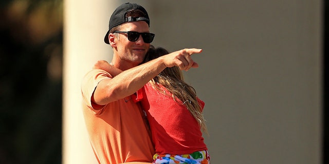 Tom Brady of the Tampa Bay Buccaneers hugs his daughter Vivian to celebrate their Super Bowl LV victory during a boat parade through town on February 10, 2021 in Tampa, Fla. (Mike Ehrmann / Getty Images)