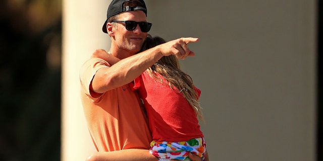Tom Brady of the Tampa Bay Buccaneers hugs his daughter Vivian celebrating their Super Bowl LV victory during a boat parade through the city on Feb. 10, 2021, in Tampa, Fla. (Mike Ehrmann/Getty Images)