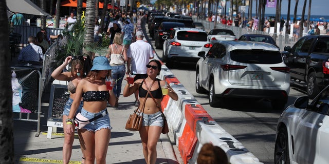 FORT LAUDERDALE, FLORIDA - MARCH 04: People walk near the beach on March 04, 2021 in Fort Lauderdale, Florida. College students have begun to arrive in the South Florida area for the annual spring break ritual. City officials are anticipating a large spring break crowd as the coronavirus pandemic continues. They are advising people to wear masks if they cannot social distance. (Photo by Joe Raedle/Getty Images)