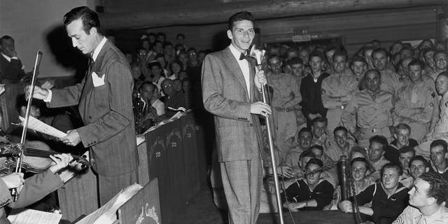 American singer and actor Frank Sinatra performs with Harry James and his orchestra on stage at a concert for American servicemen at the Hollywood Canteen in California.