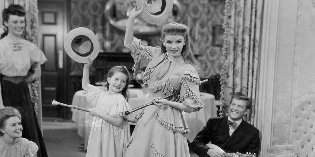 Actresses Margaret O'Brien and Judy Garland dancing with hats and canes, in a scene from the movie 'Meet Me in St Louis', 1944.