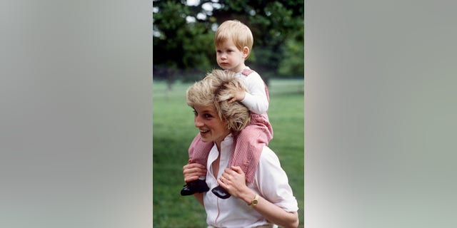 Princess Diana carries Prince Henry (Harry) on her shoulders at Highgrove.