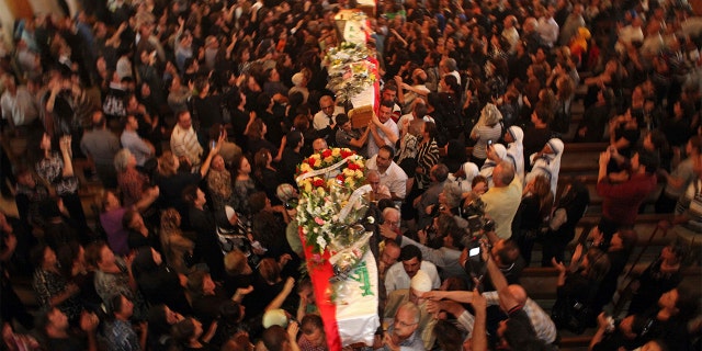 File - In this Tuesday Nov. 2, 2010 file photo, mourners carry the coffins of slain Christians during their funeral in Baghdad, Iraq, who were killed Sunday when gunmen stormed a church during mass and took the entire congregation hostage. (AP Photo/Khalid Mohammed, File)
