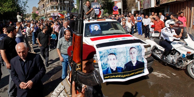 File - In this Tuesday, Nov. 2, 2010 file photo, the coffins of two slain priests and their parishioners arrive at a funeral mass in Baghdad, Iraq. (AP Photo/Hadi Mizban, File)