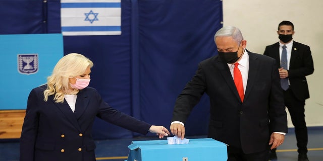 Israeli Prime Minister Benjamin Netanyahu and his wife Sara cast their ballots at a polling station as Israelis vote in a general election in Jerusalem on Tuesday. (AP)