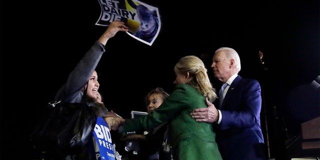 A protester at left, is held back by Jill Biden, center, and her husband, Democratic presidential candidate former Vice President Joe Biden, right, during a primary election night rally Tuesday, March 3, 2020, in Los Angeles. (AP Photo/Marcio Jose Sanchez)