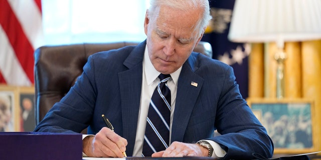 President Joe Biden signs the American Rescue Plan, a coronavirus relief package, in the Oval Office of the White House, Thursday, March 11, 2021, in Washington.