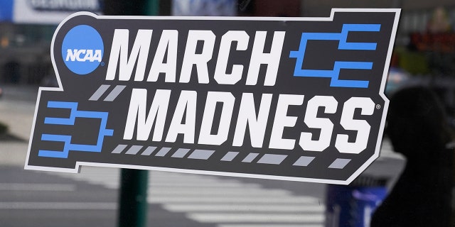 A March Madness sticker for the NCAA college basketball tournament is placed on a window in downtown Indianapolis, Wednesday, March 17, 2021. (AP Photo/Darron Cummings)